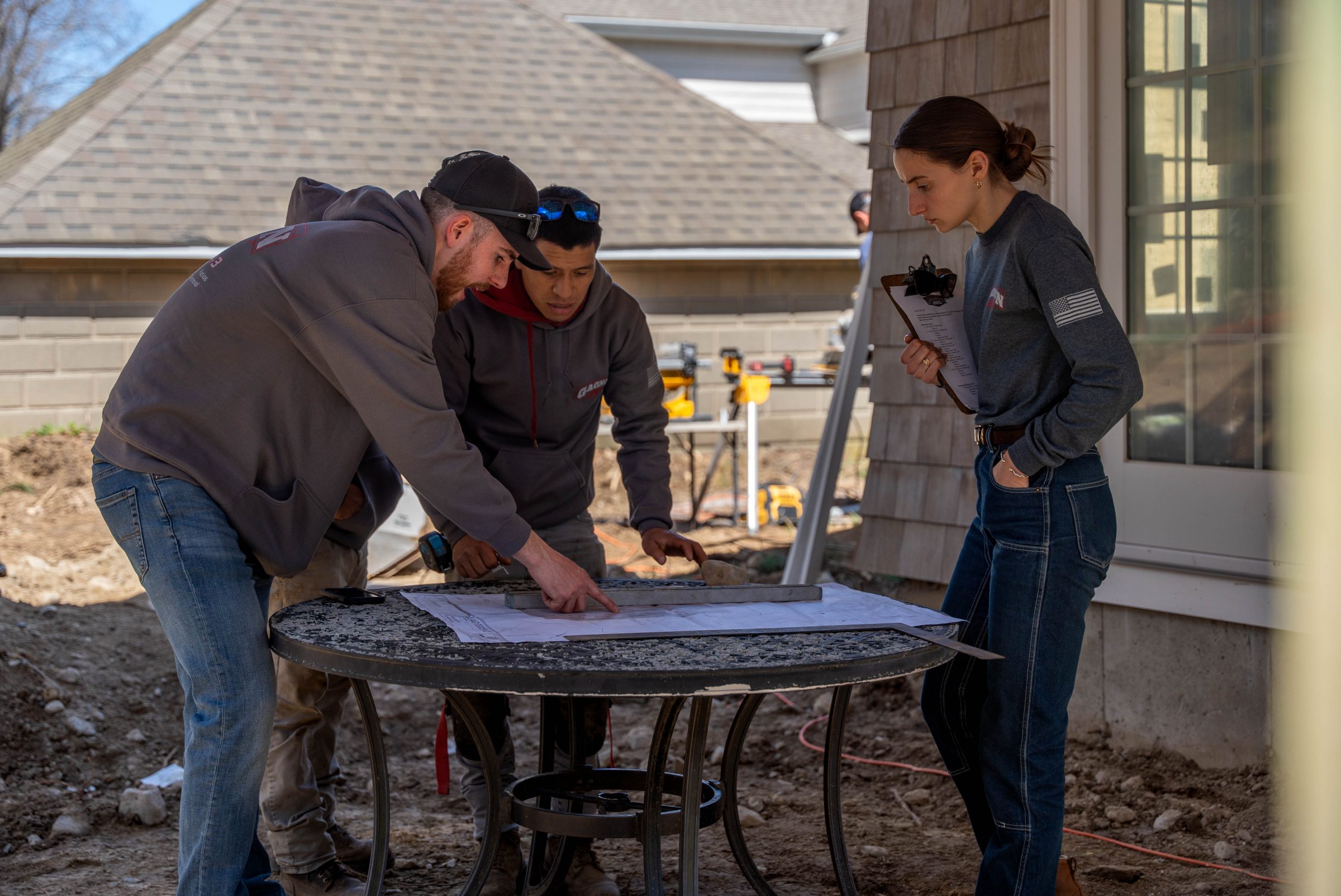 Construction team reviewing blueprints outside residential building