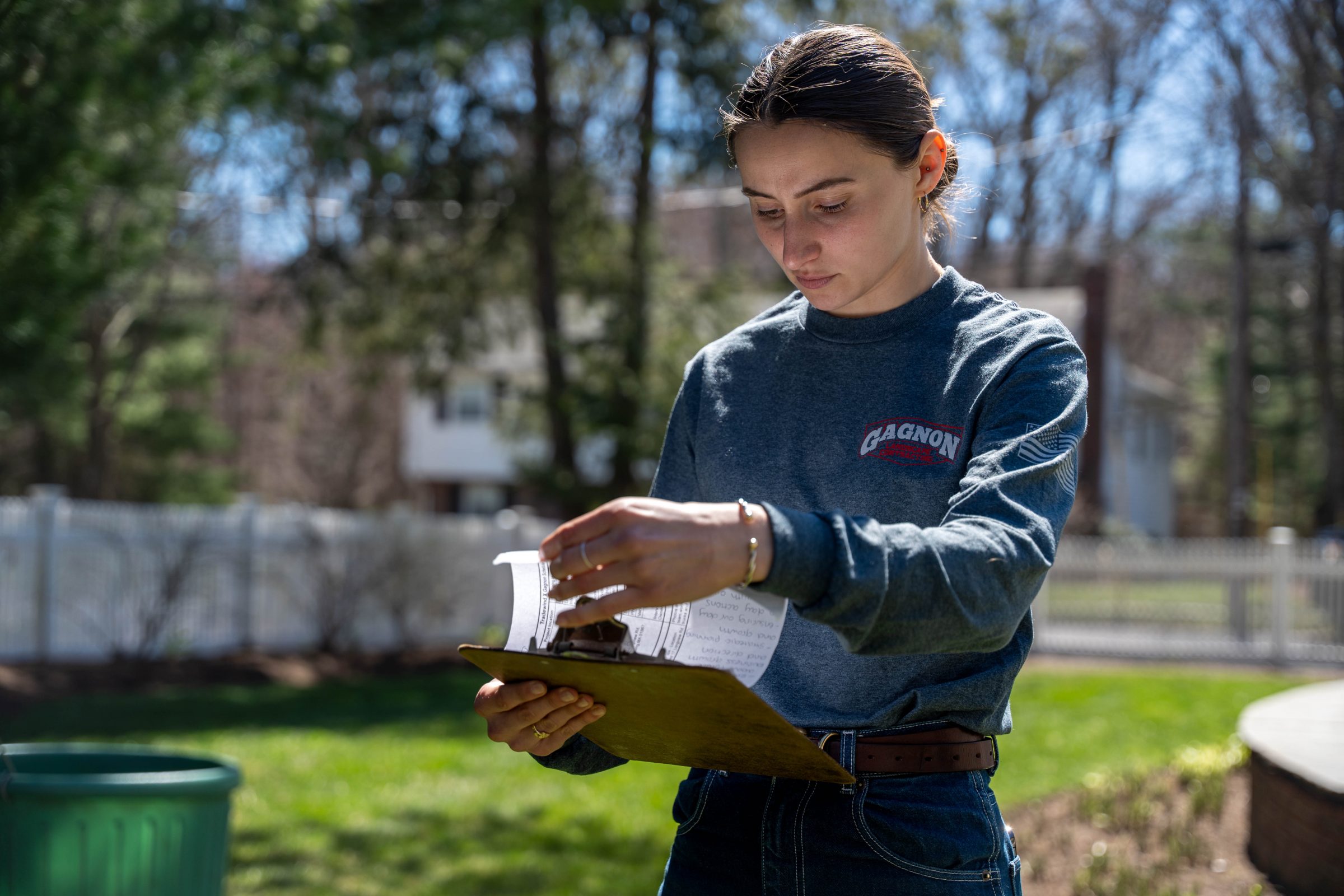Woman reviewing papers on clipboard outdoors