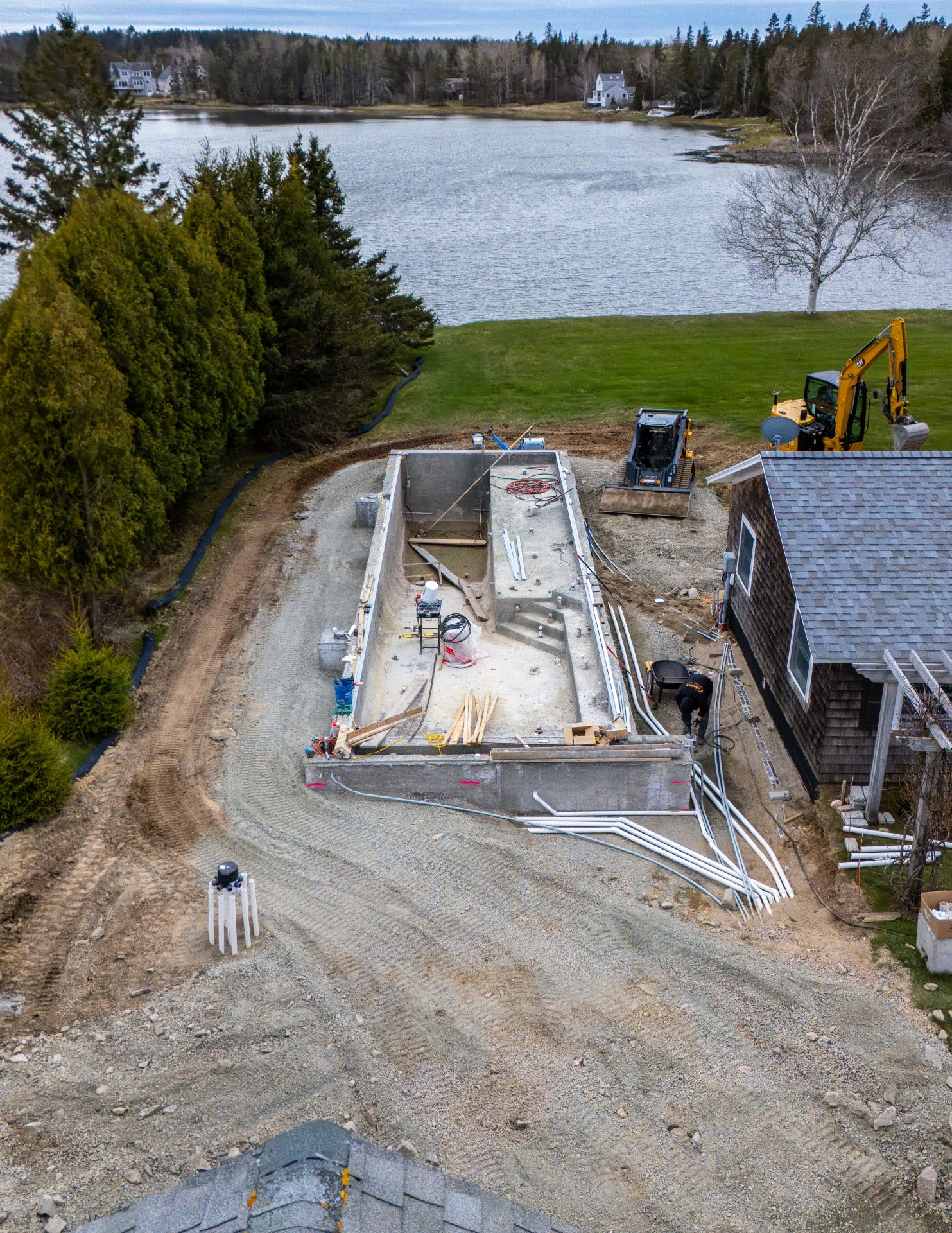 Lakeside home construction with concrete pool foundation