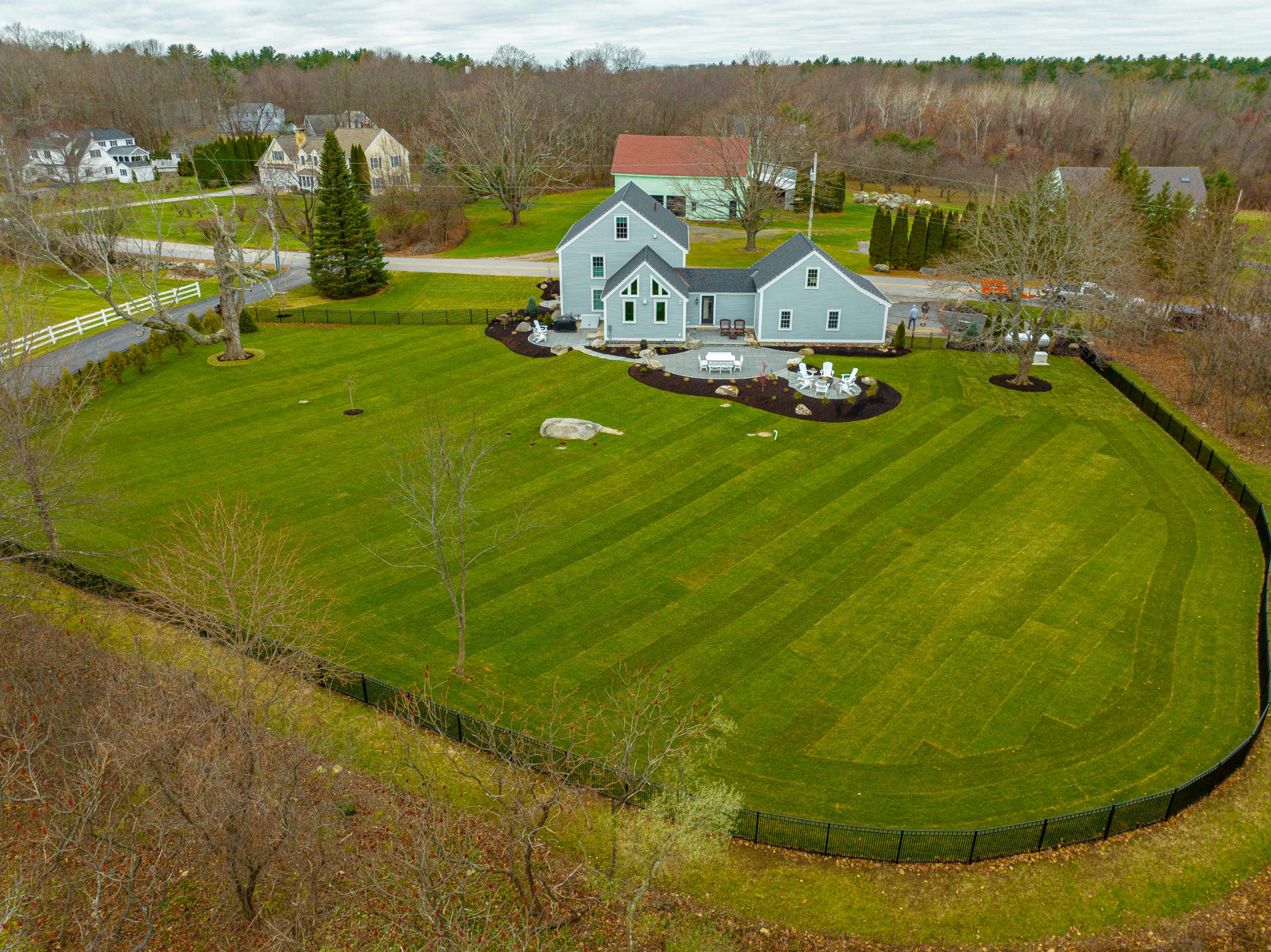 Aerial view of house with expansive fenced lawn