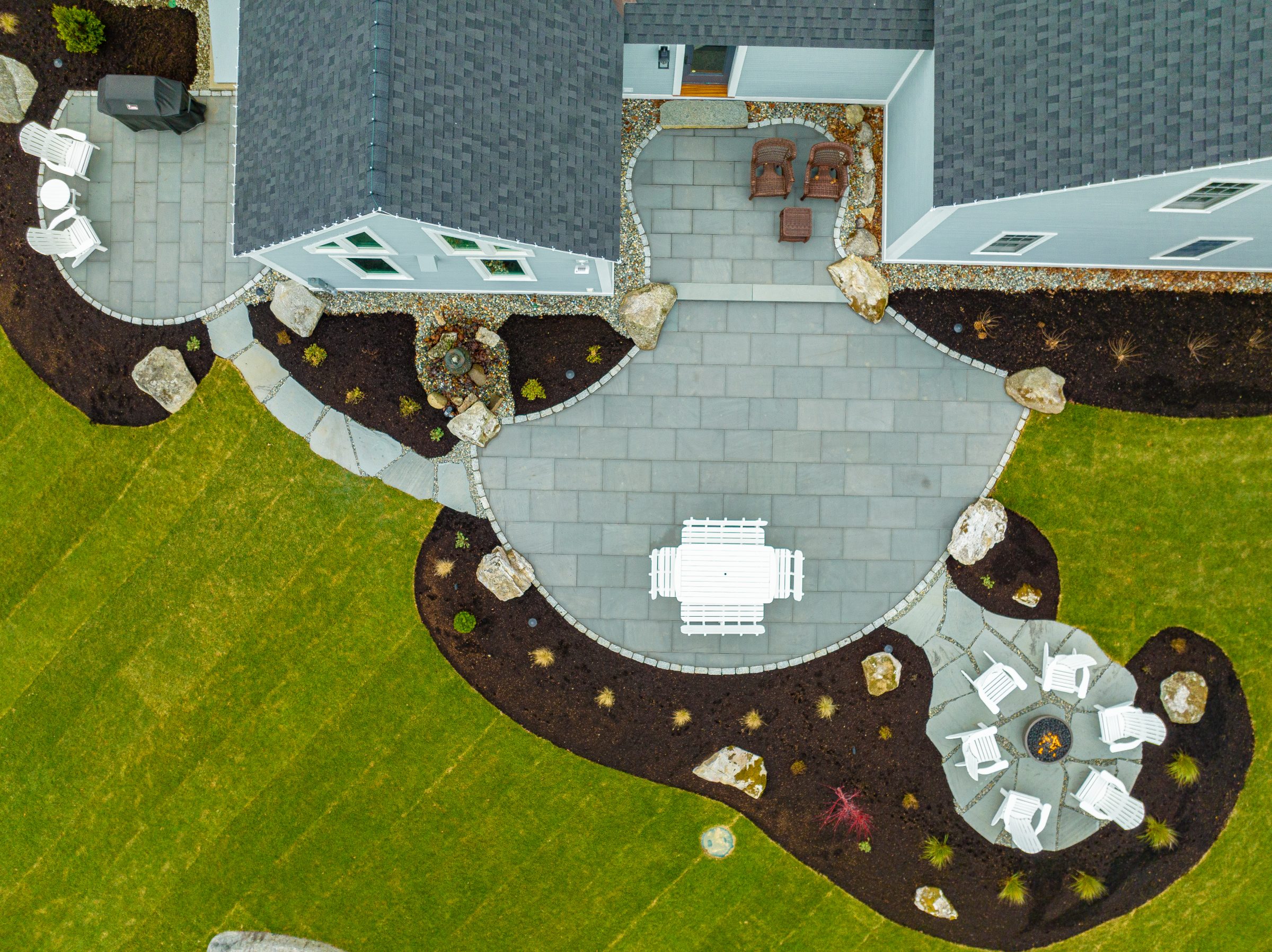 Aerial view of landscaped backyard patio and fire pit