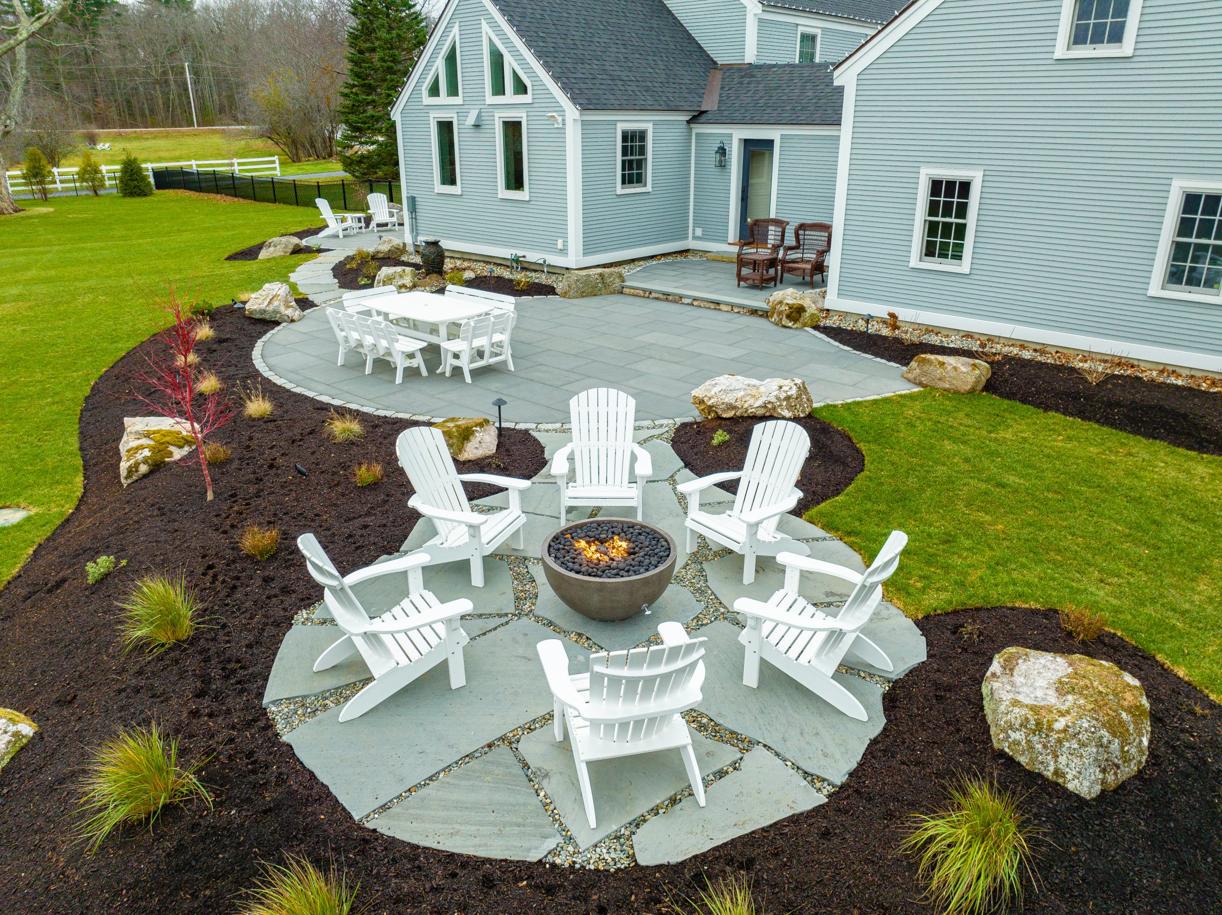 Backyard patio with fire pit and Adirondack chairs