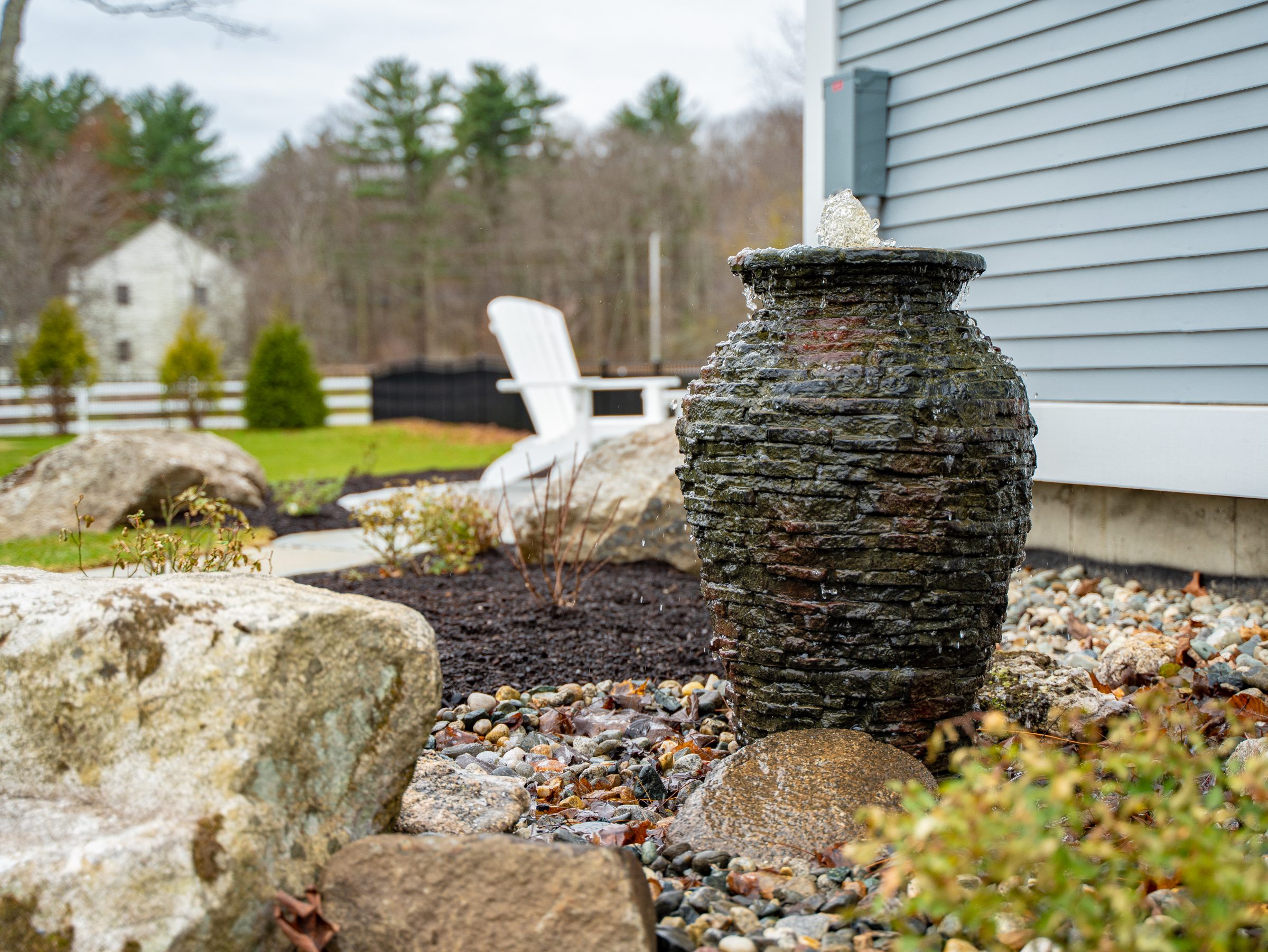 Stone urn fountain in landscaped backyard garden