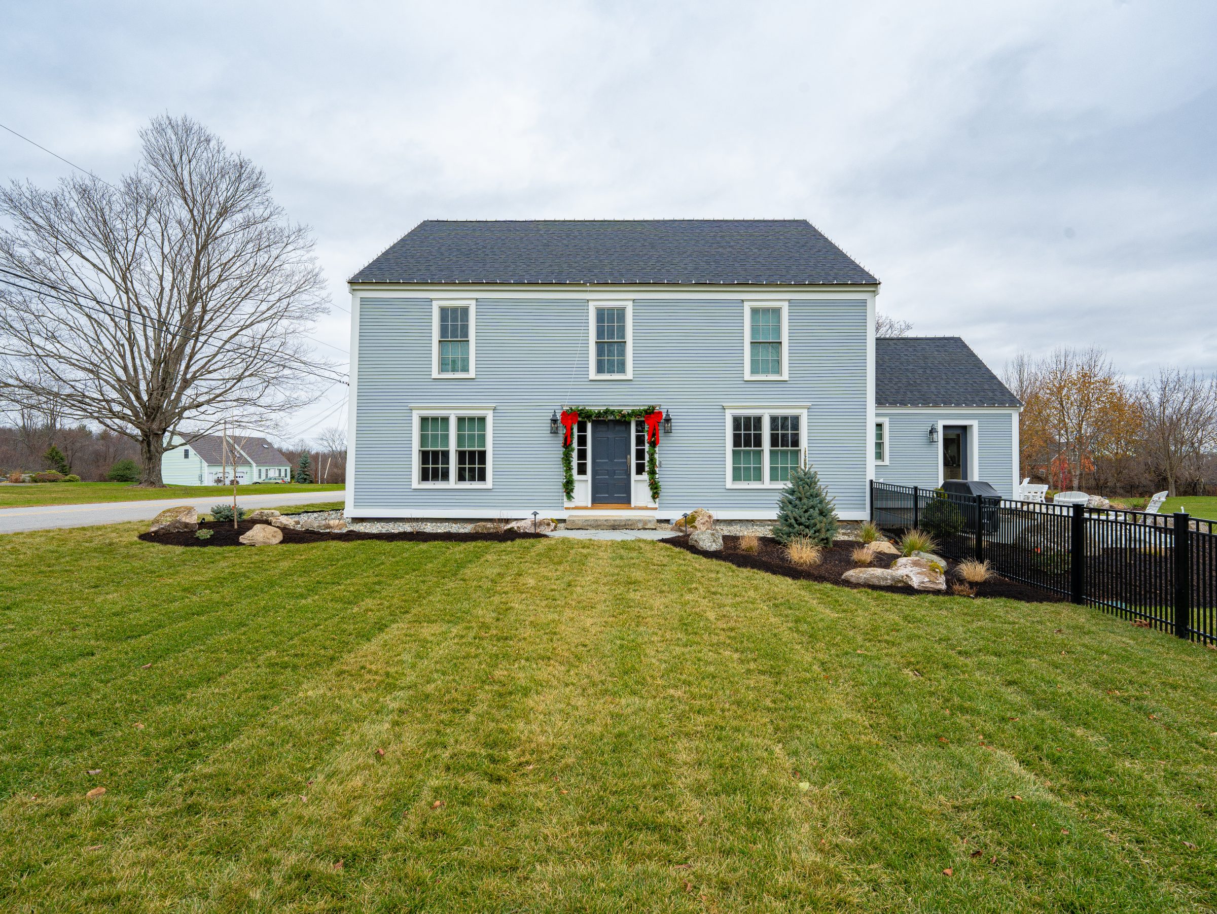 Light blue two-story home with holiday decorations