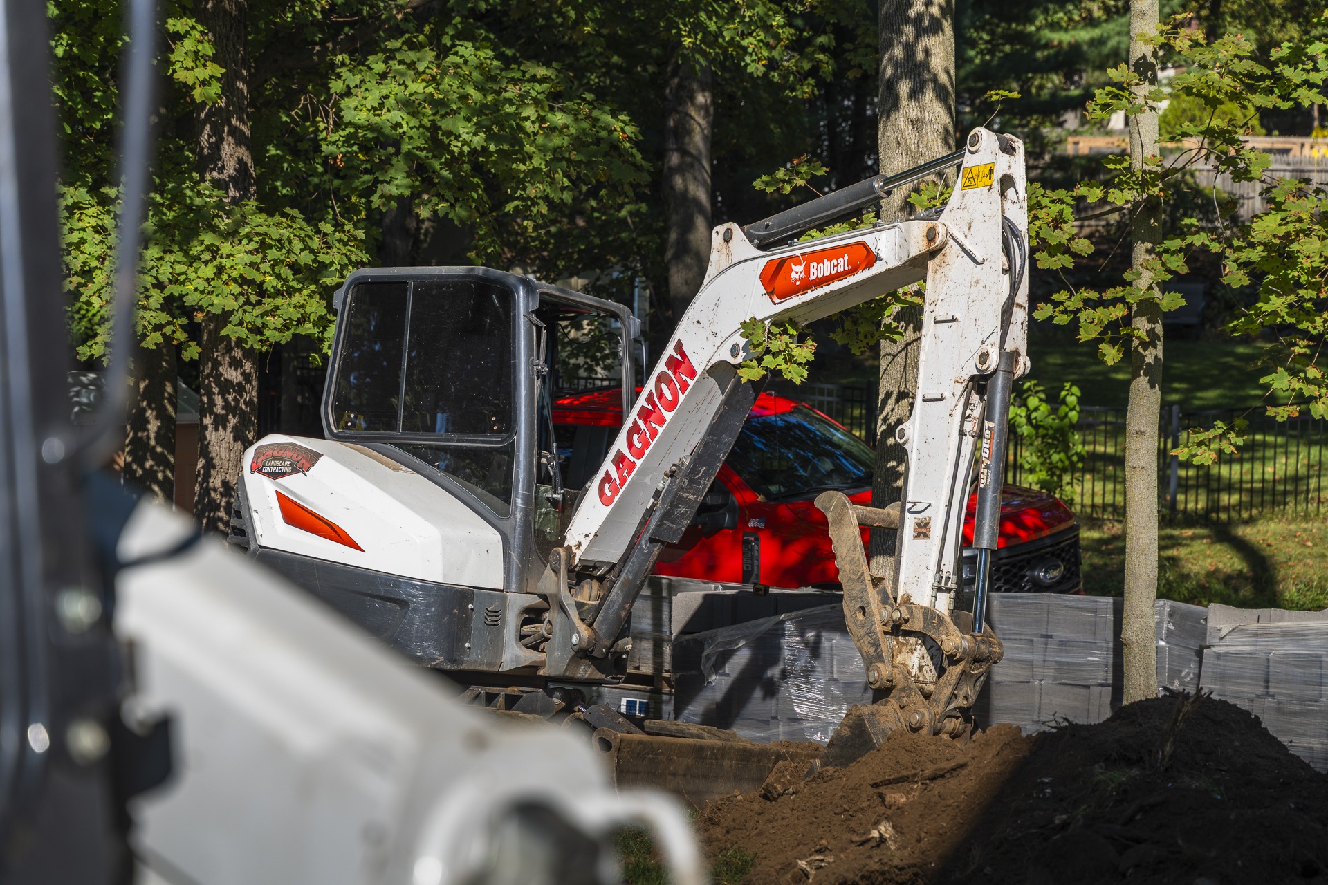 Bobcat mini excavator digging trench in yard
