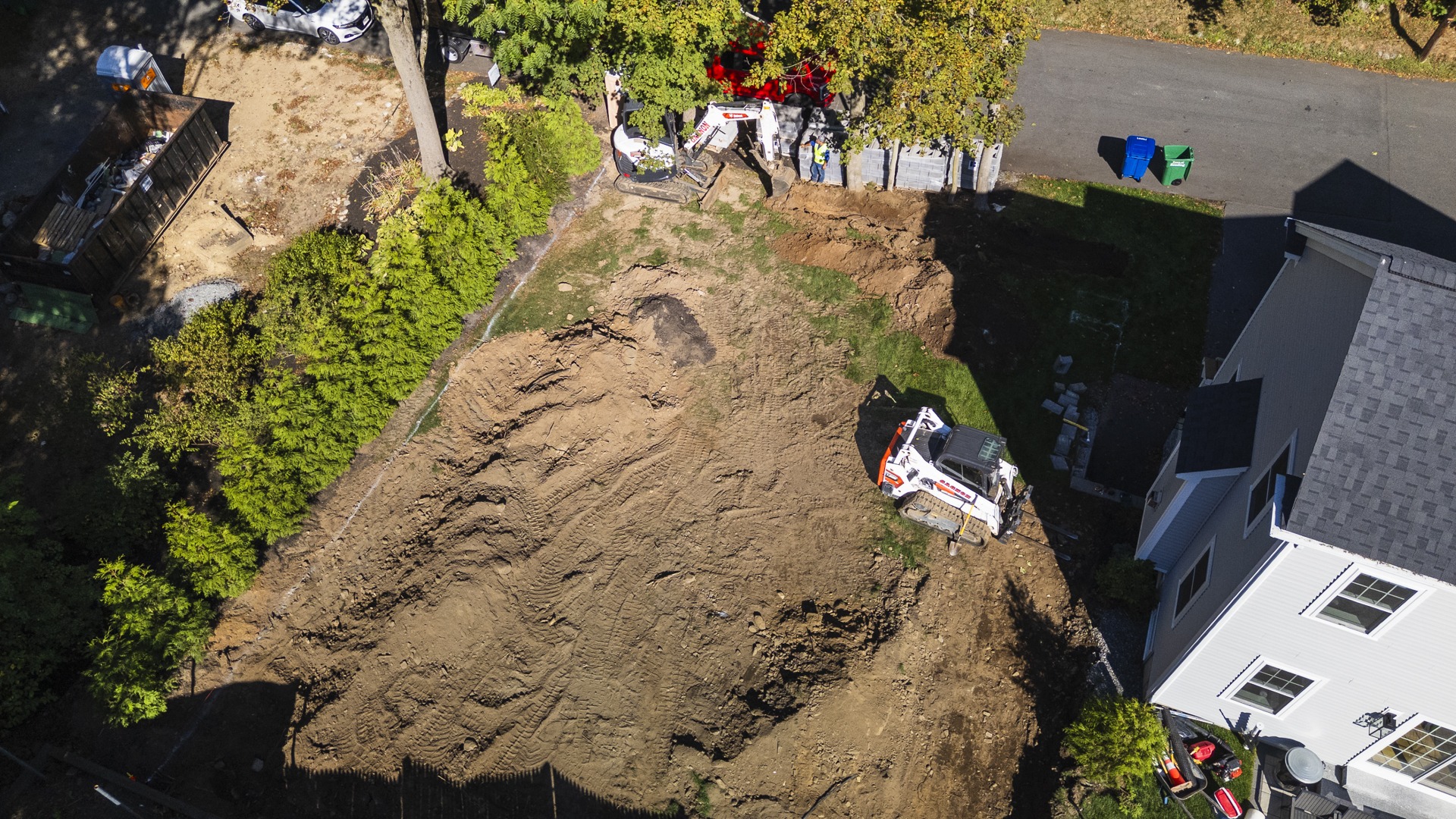 Aerial view of backyard excavation with heavy machinery