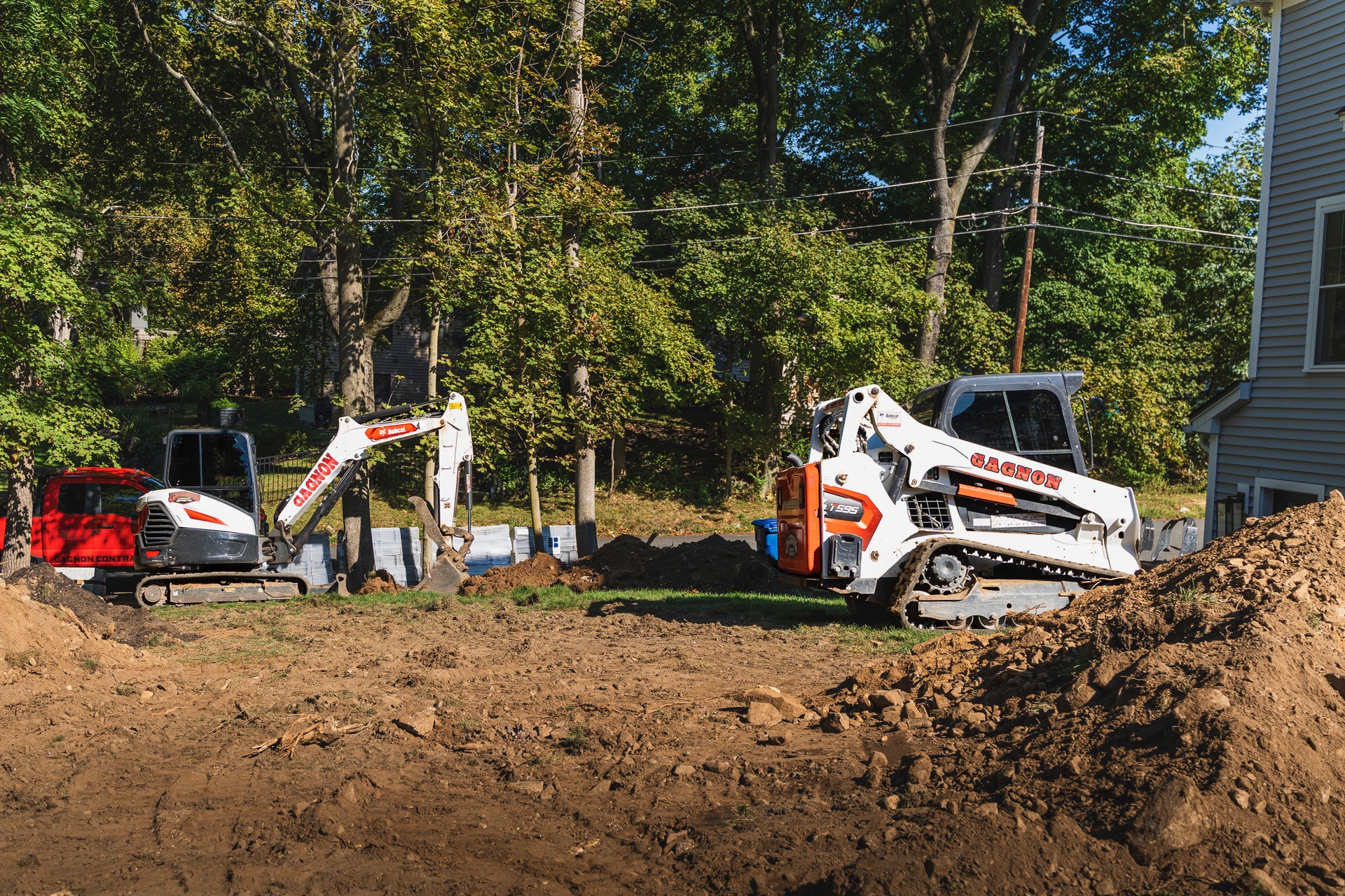 Mini excavator and skid-steer at residential construction site