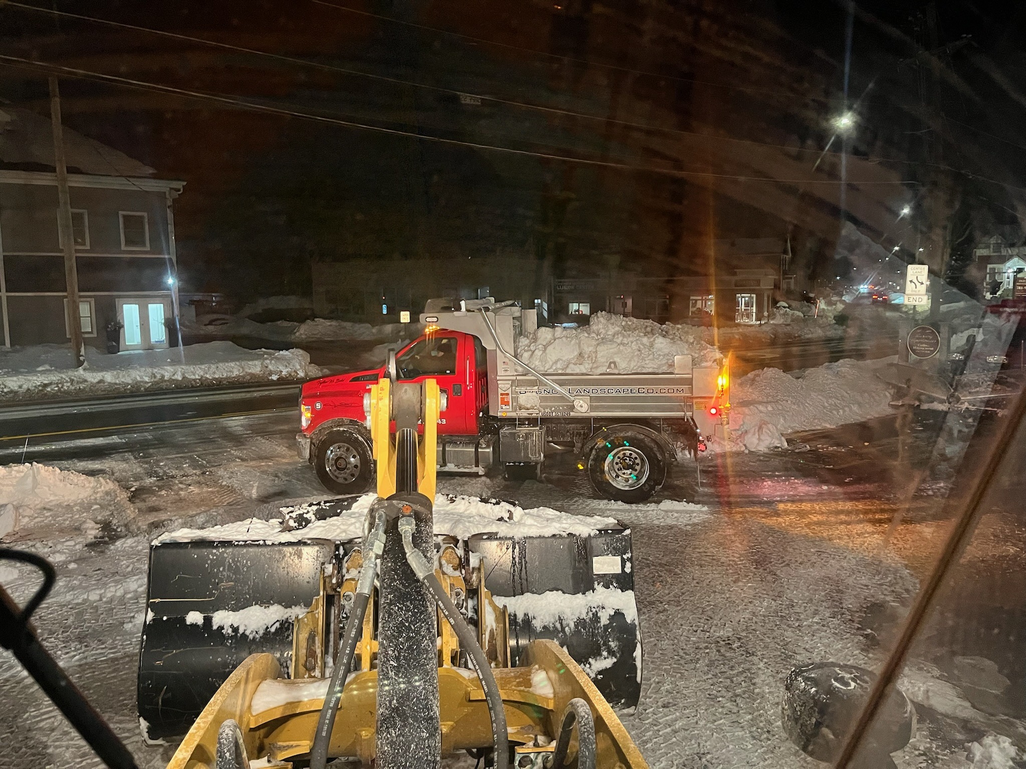 Snowplow clearing snowy street at night