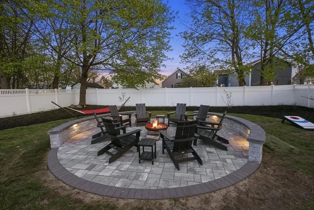 Circular backyard patio with fire pit and chairs