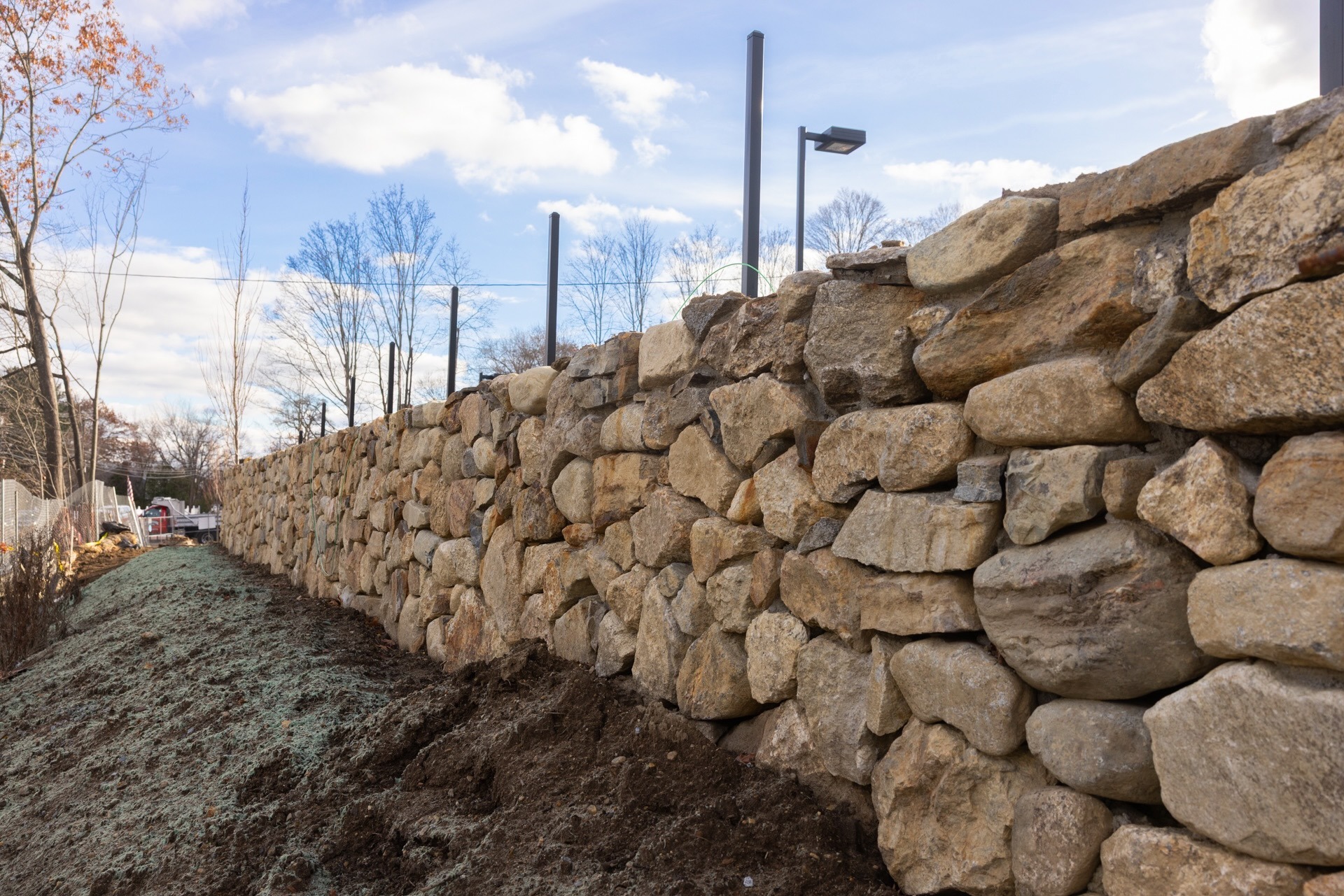 Long stacked stone retaining wall outdoors