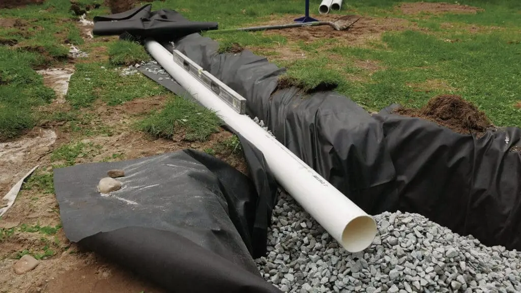 PVC drainage pipe in gravel-lined trench