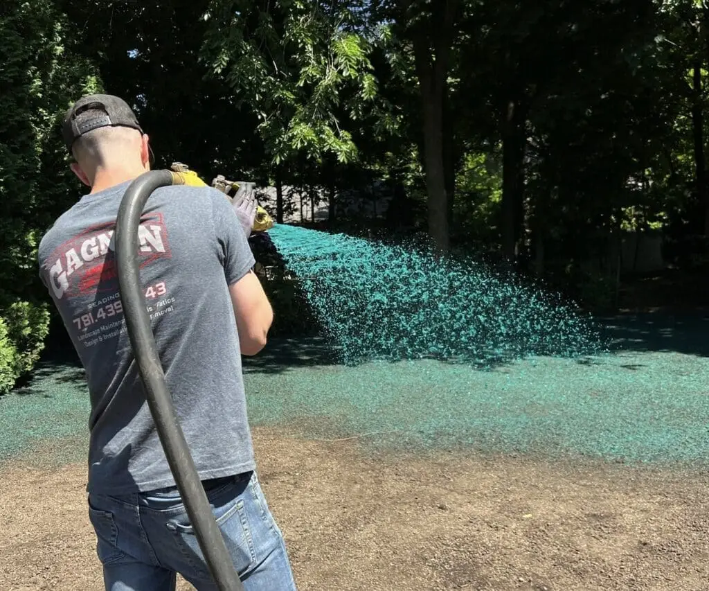 Person with hydro seeding setup spraying ground