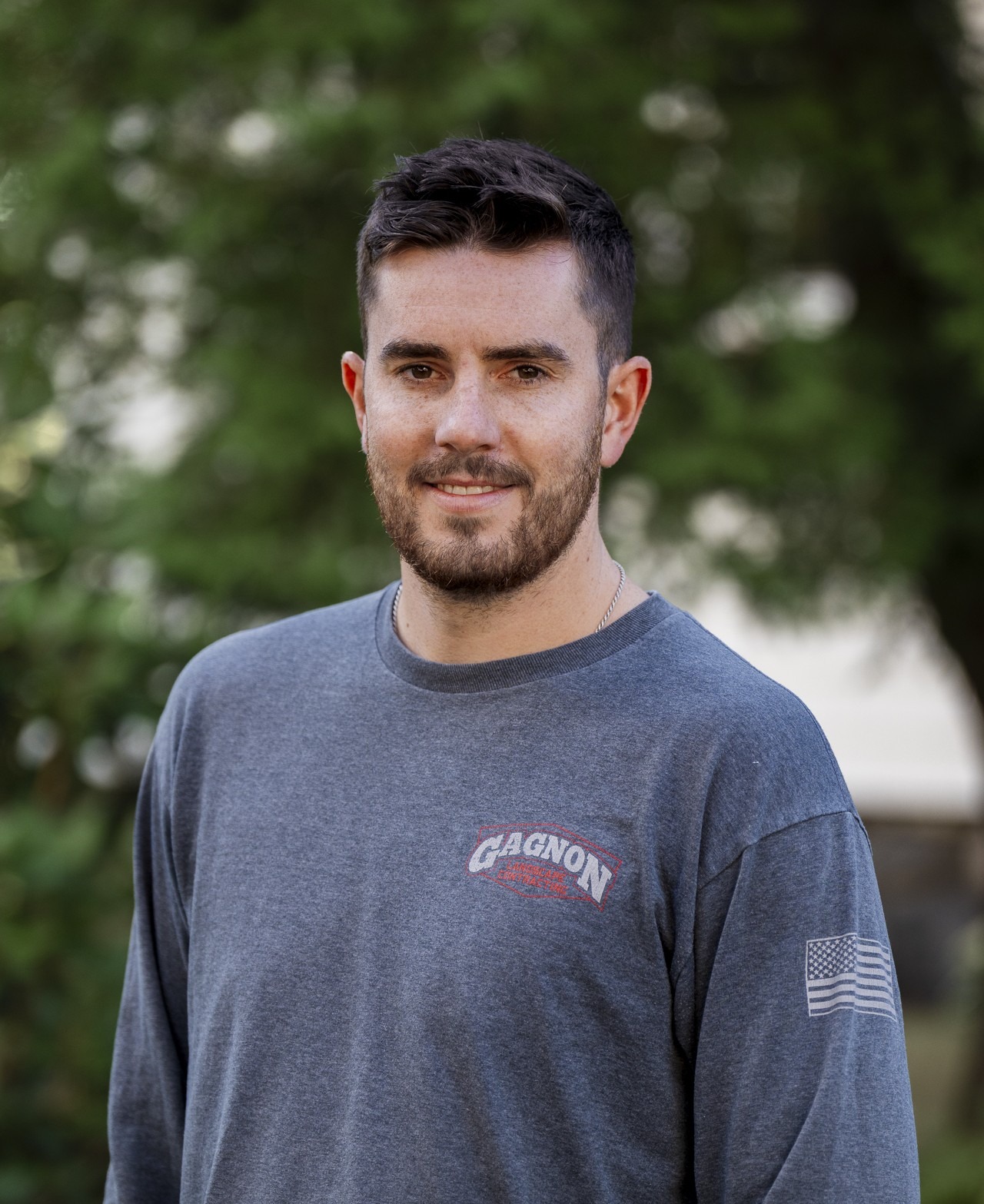 Bearded man in gray shirt outdoors