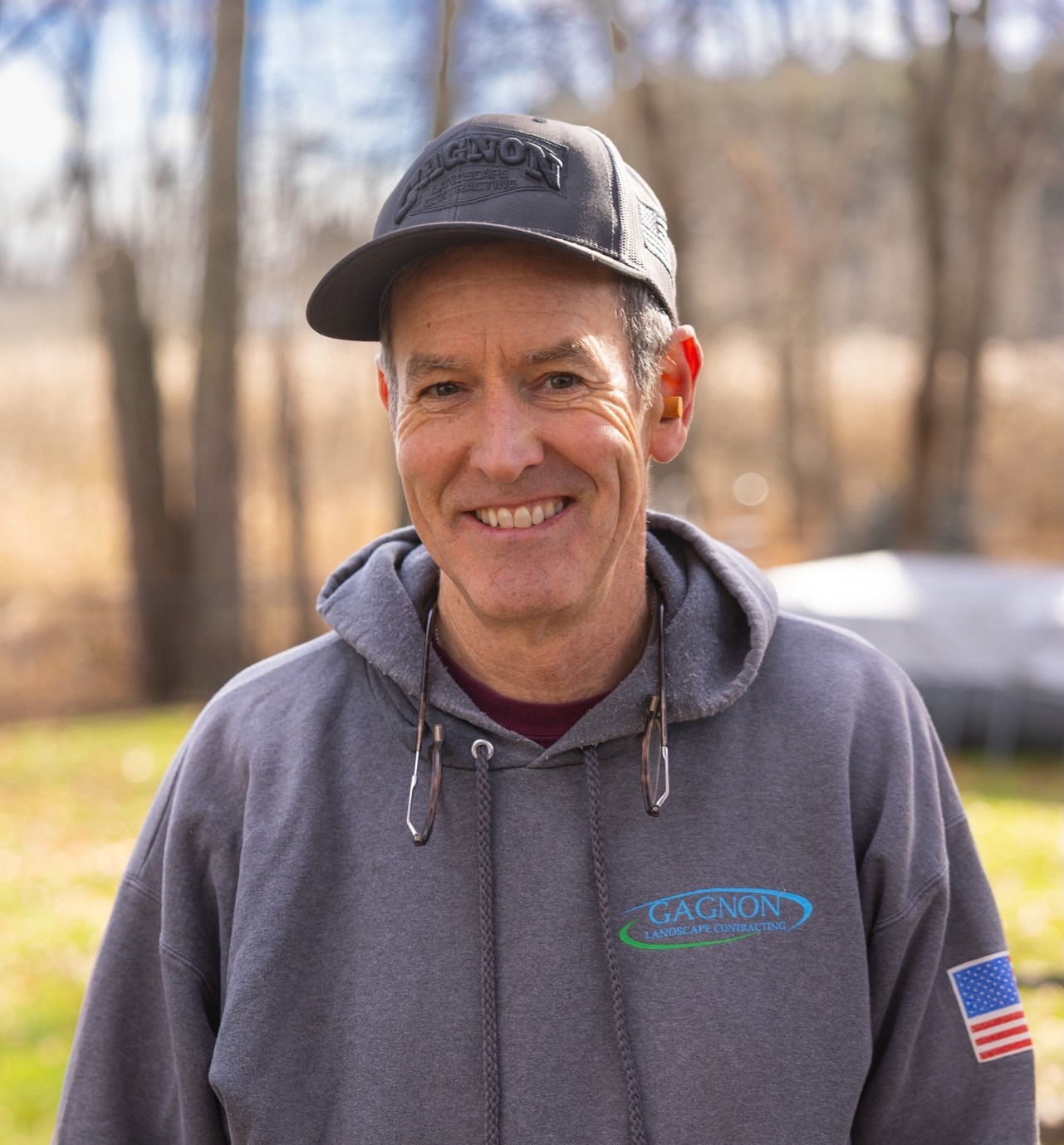 Smiling man in gray hoodie outdoors