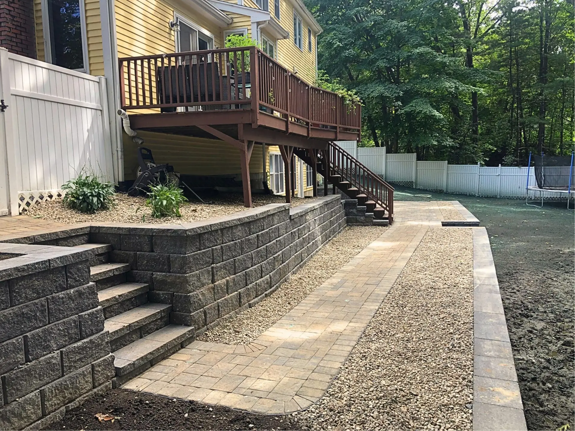 Backyard deck with retaining wall and paver walkway