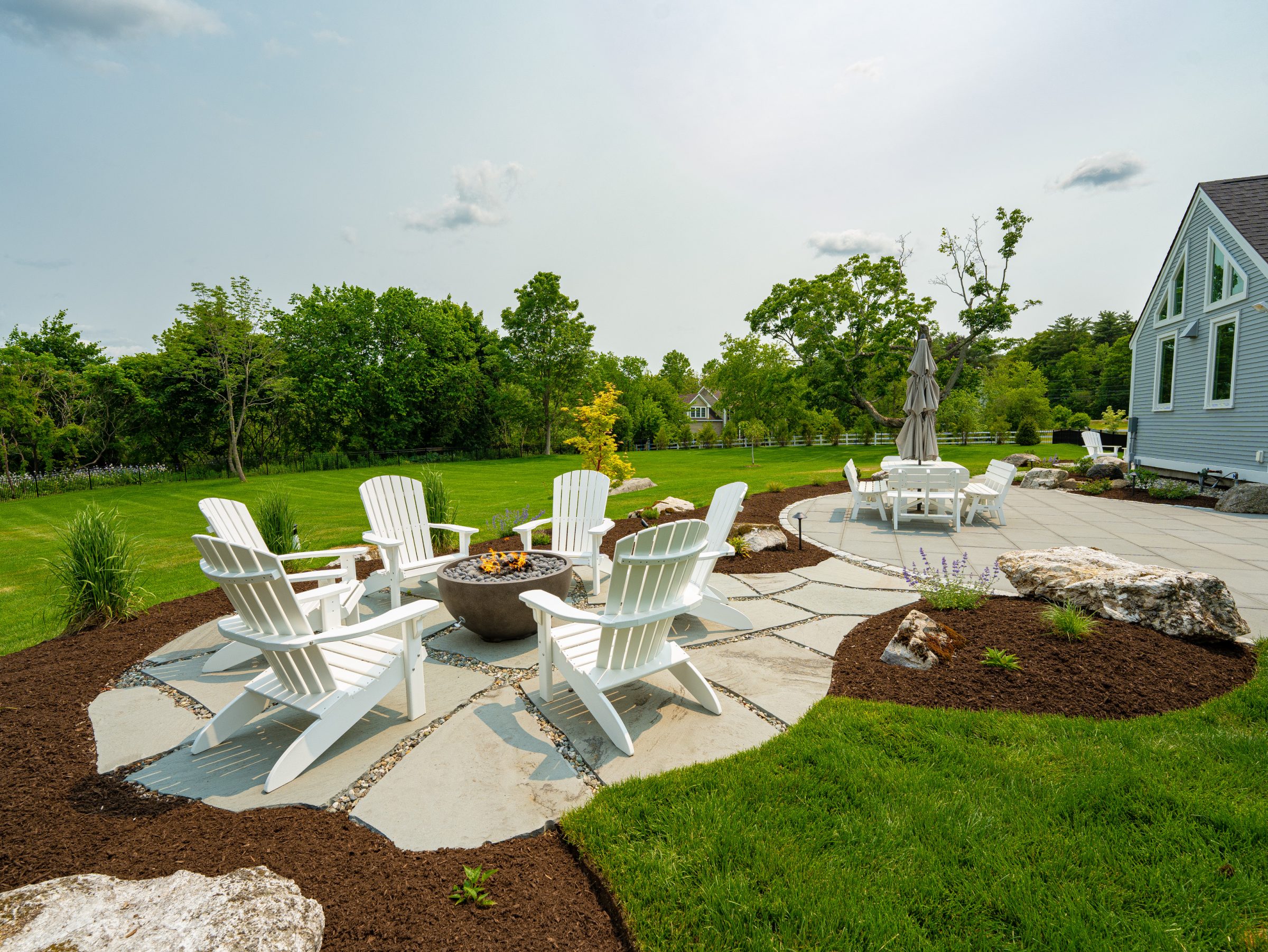 Backyard patio with fire pit and Adirondack chairs