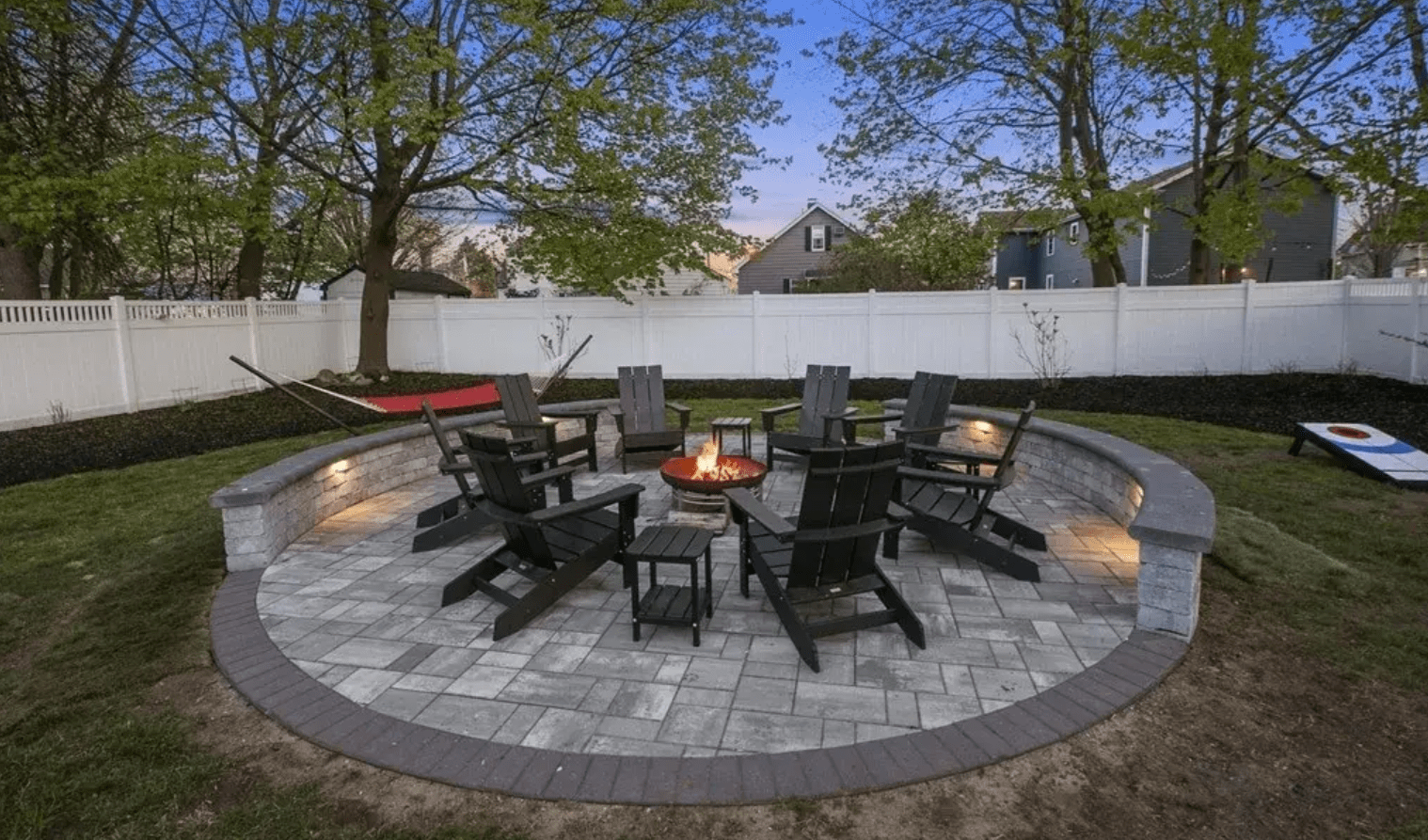 Backyard patio with fire pit and Adirondack chairs