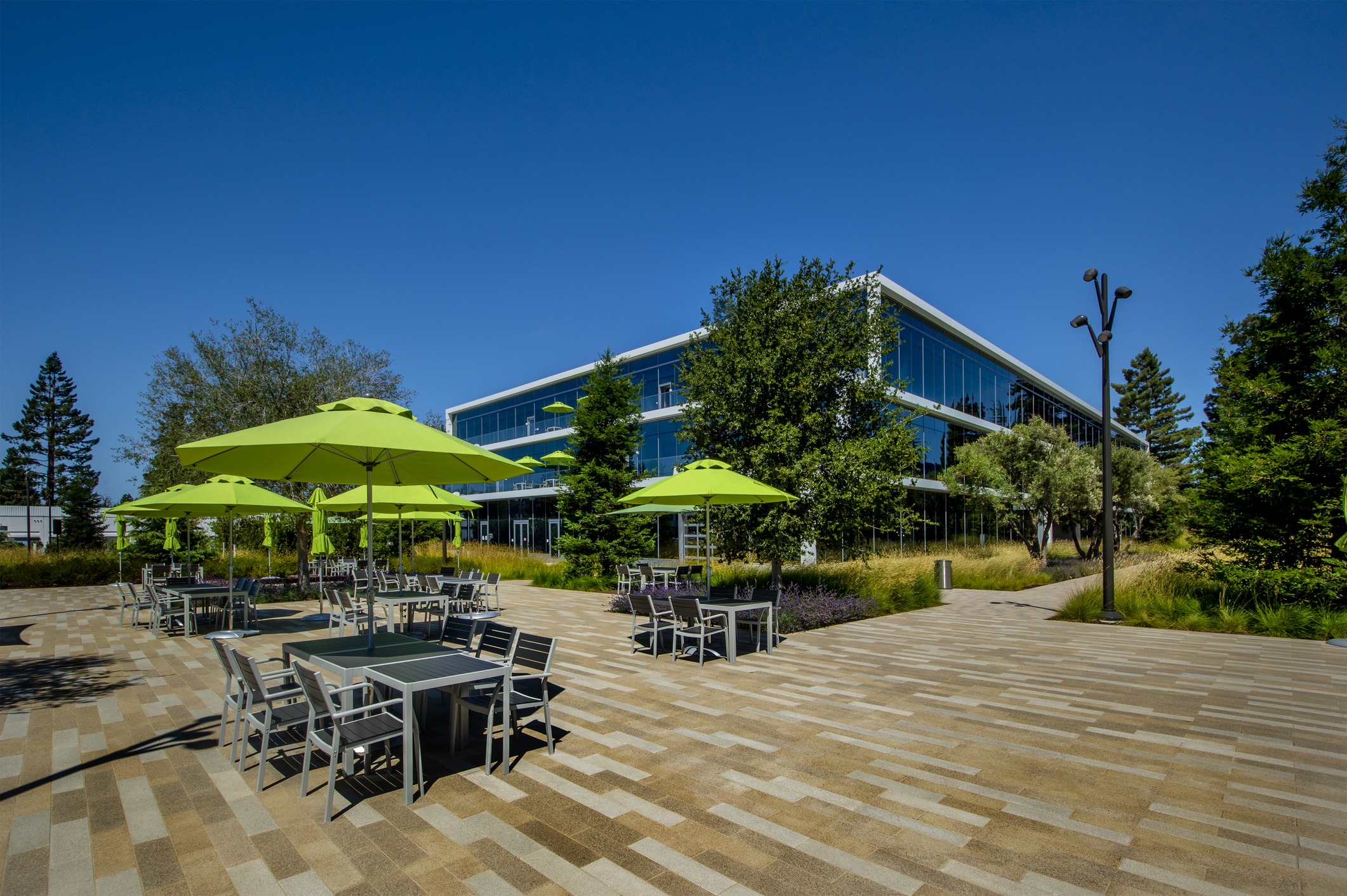 Modern office building with patio and green umbrellas