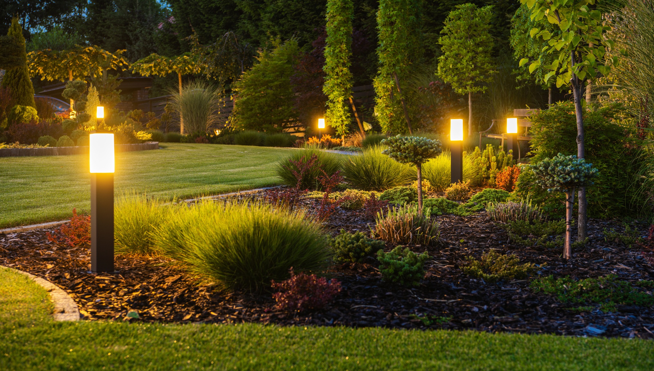 Modern garden pathway lights illuminating landscaped backyard at dusk
