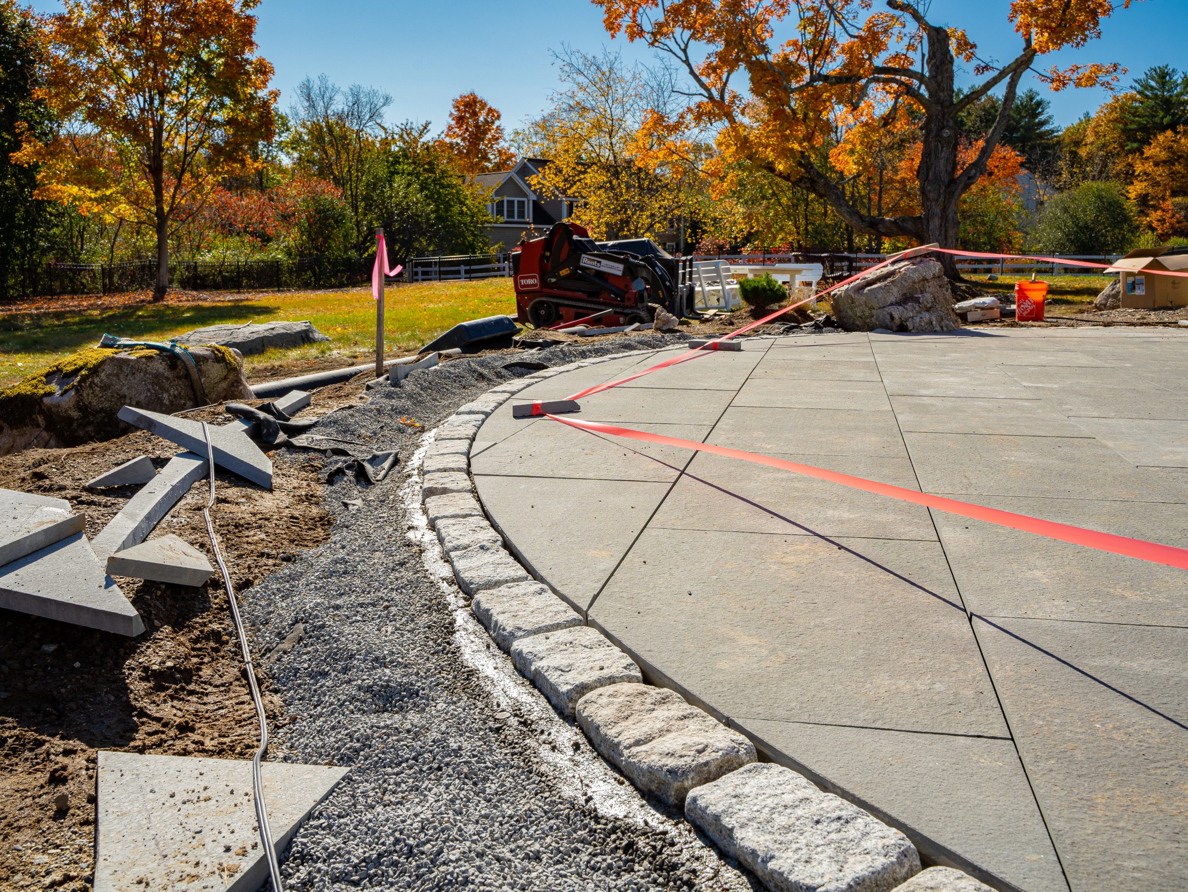 Landscaping project with curved patio and autumn trees